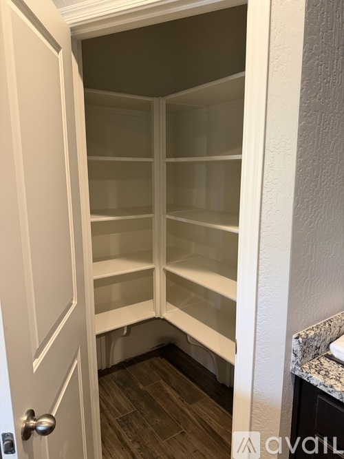 A white door is open to a room with empty shelves.