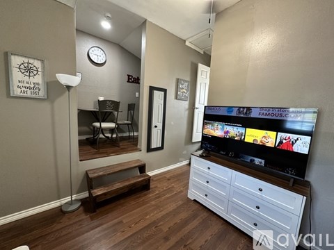 A living room with a flat screen TV and a wooden bench.