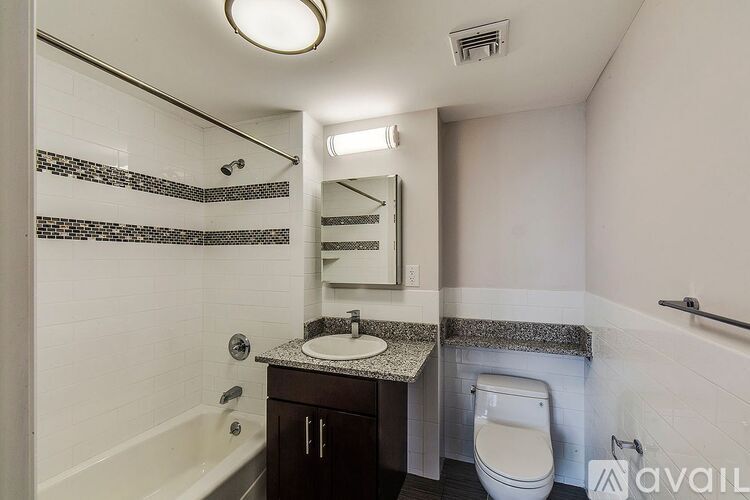 A bathroom with a white toilet, a sink, a mirror, and a bathtub.
