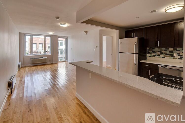 A kitchen with a refrigerator, cabinets, and a countertop is available for rent.