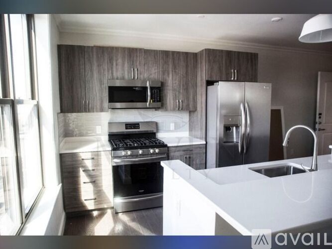 A modern kitchen with a stainless steel refrigerator and a white countertop.