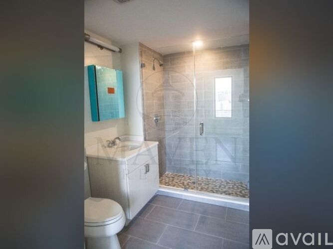 A bathroom with a toilet, sink, and shower area.