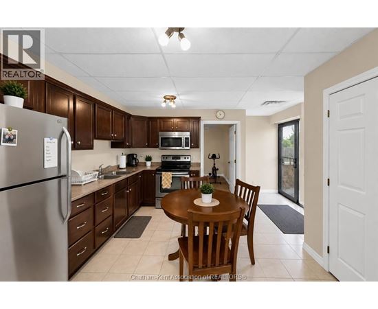A kitchen with brown cabinets and a refrigerator.