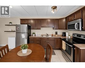 A kitchen with brown cabinets and a wooden table.
