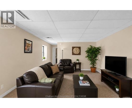 A living room with a brown leather couch and a flat screen TV.