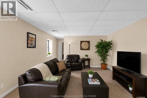 A living room with a brown leather couch and a flat screen TV.