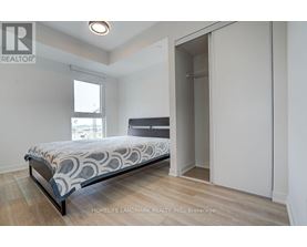 A bedroom with a bed, wooden floors, and a window.