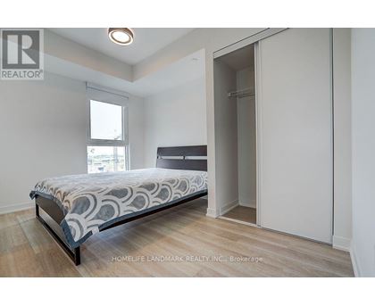 A bedroom with a bed, wooden floors, and a window.