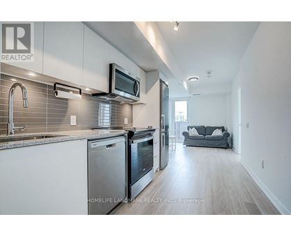 A modern kitchen with stainless steel appliances and a microwave mounted above the oven.