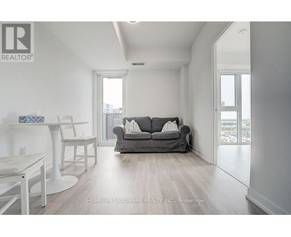 A living room with a grey couch and a white table.