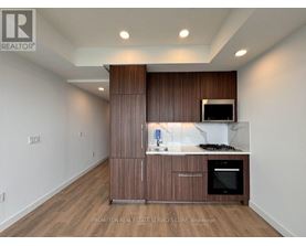 A kitchen area with a microwave, oven, and cabinets.