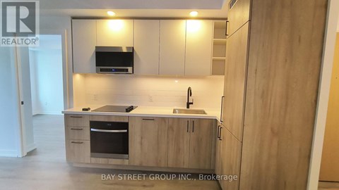A kitchen with wooden cabinets and a stainless steel oven.