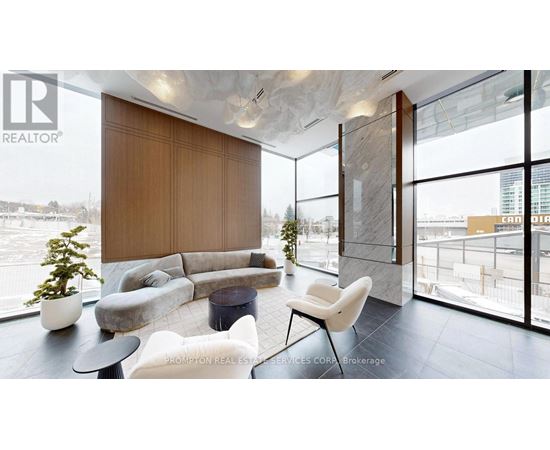 A living room with a couch, chair, and a potted plant.