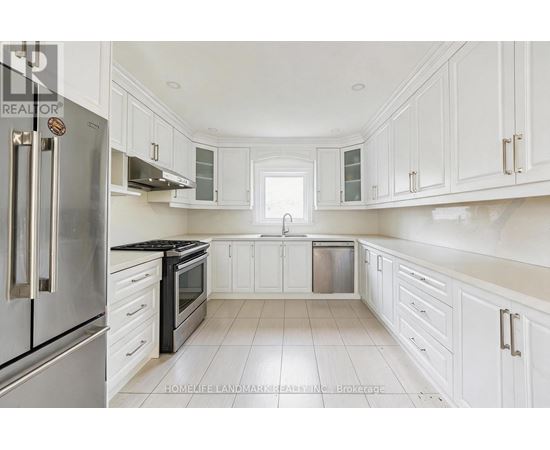 A kitchen with white cabinets and a stainless steel refrigerator.