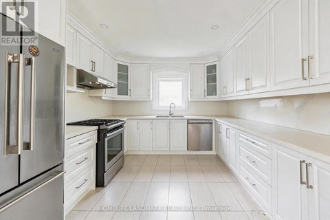 A kitchen with white cabinets and a stainless steel refrigerator.
