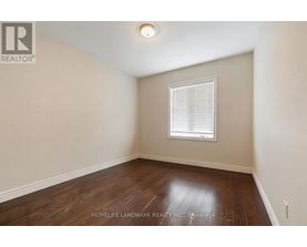 A room with a window and wooden flooring.