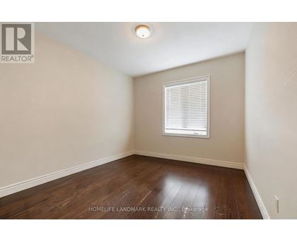 A room with a window and wooden flooring.