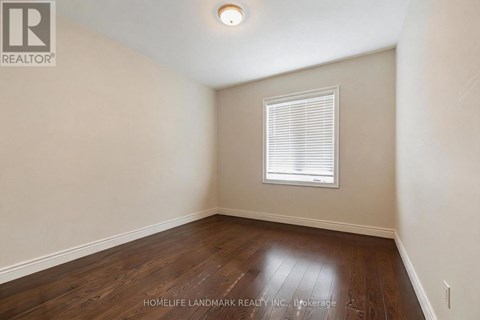 A room with a window and wooden flooring.