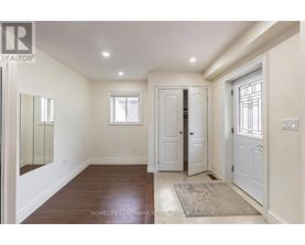 A hallway with a wooden floor and white walls.