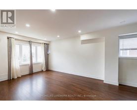 A spacious room with wooden floors and white walls.
