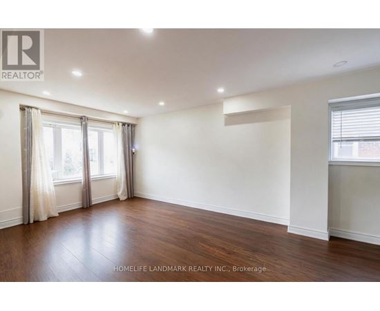 A spacious room with wooden floors and white walls.