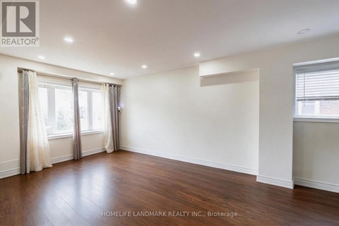 A spacious room with wooden floors and white walls.