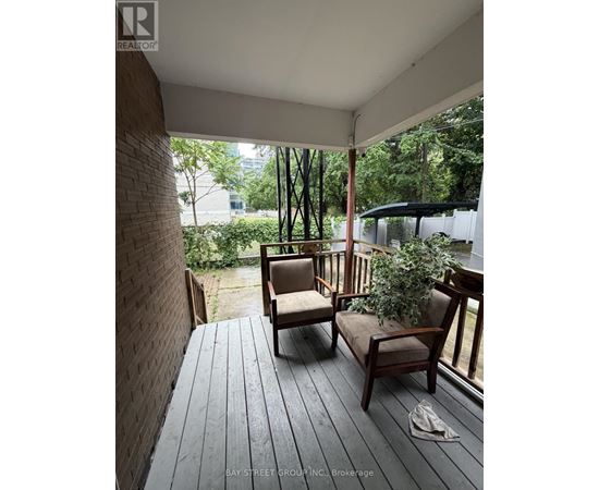 A wooden deck with two chairs and a potted plant.