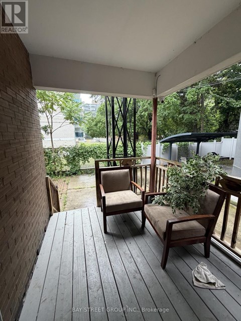 A wooden deck with two chairs and a potted plant.