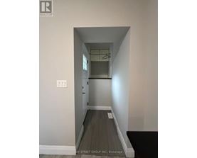 A hallway with a coat rack and a light switch.