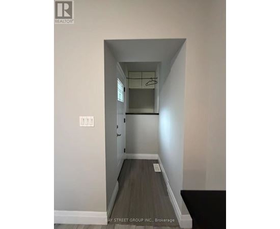 A hallway with a coat rack and a light switch.