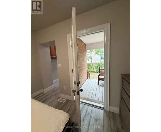 A bedroom with a bed and a door leading to a balcony.