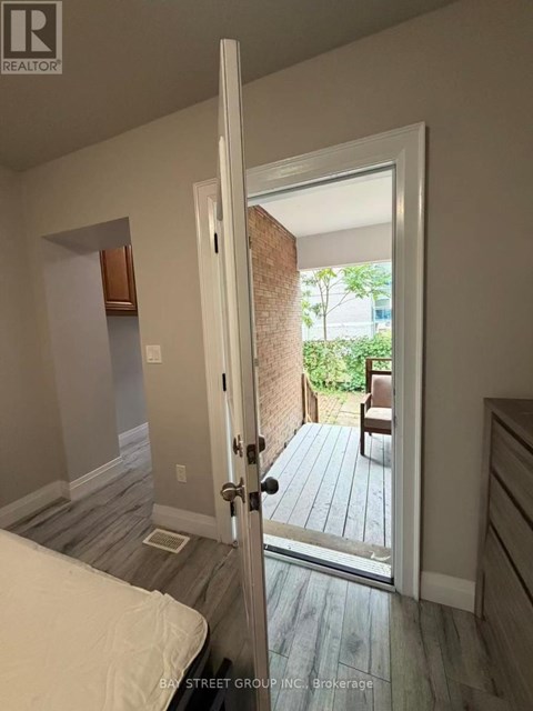 A bedroom with a bed and a door leading to a balcony.