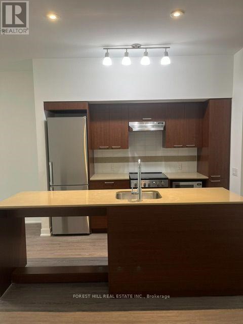 A kitchen with a sink and a refrigerator.