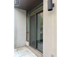 A window with a black frame and a black vent on the wall.