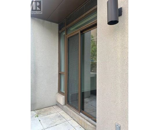 A window with a black frame and a black vent on the wall.
