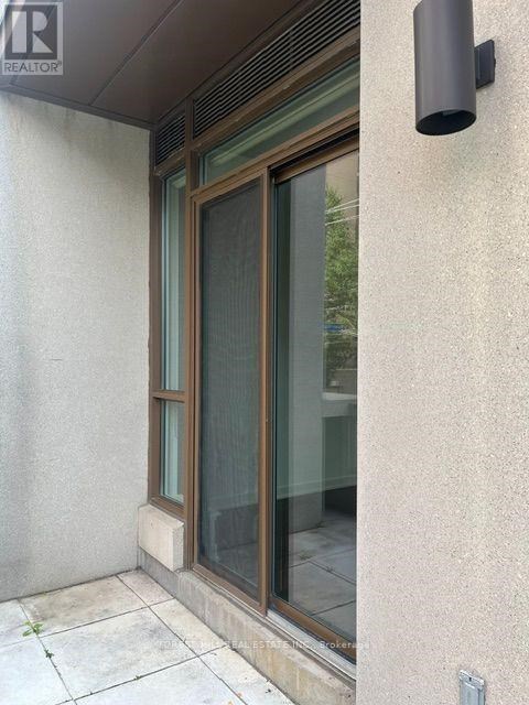 A window with a black frame and a black vent on the wall.