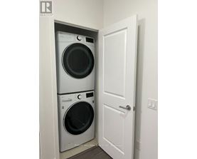 A white door is open to a small laundry room with a washer and dryer.