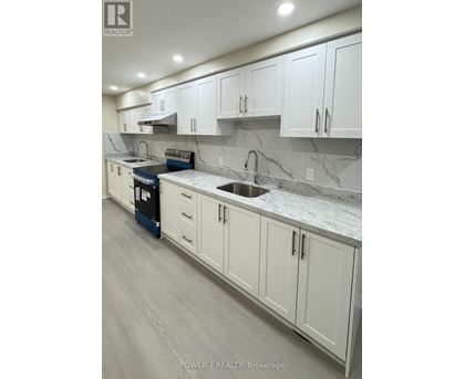 A kitchen with white cabinets and marble countertops.