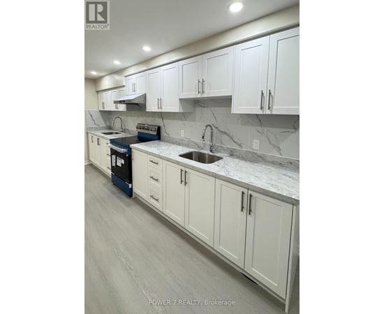 A kitchen with white cabinets and marble countertops.