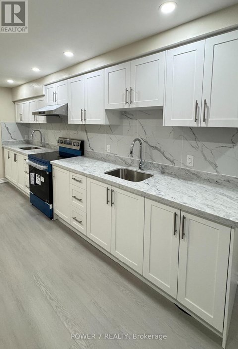A kitchen with white cabinets and marble countertops.