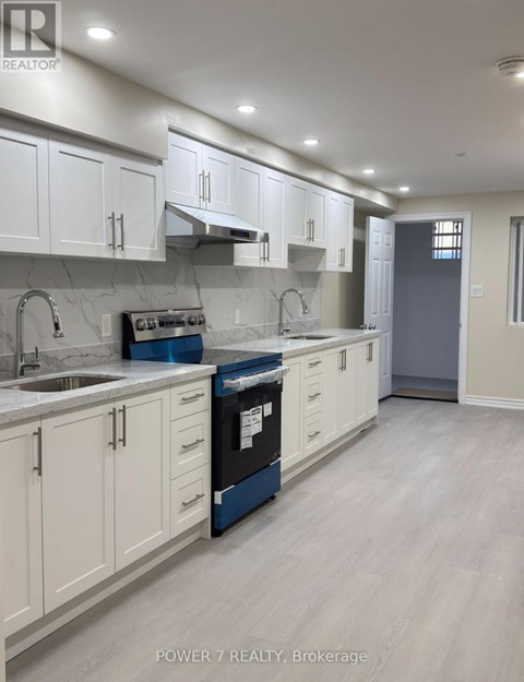 A kitchen with white cabinets and a blue dishwasher.