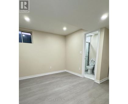 A bathroom with a toilet and a window.