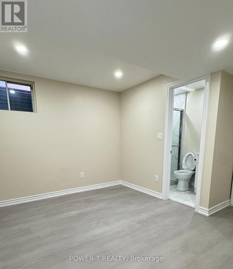 A bathroom with a toilet and a window.