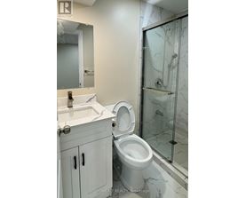 A white toilet in a bathroom with a glass shower door.