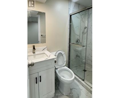 A white toilet in a bathroom with a glass shower door.