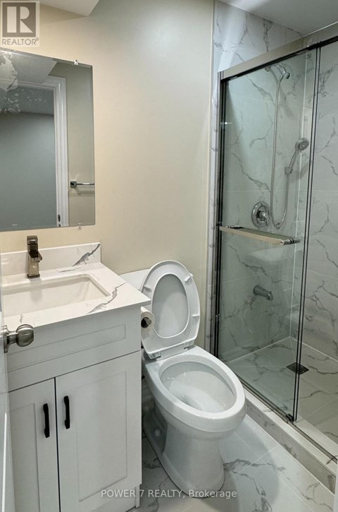 A white toilet in a bathroom with a glass shower door.