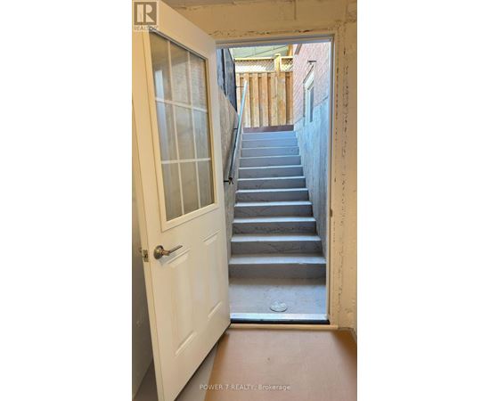 A white door with a glass window is open to a staircase.