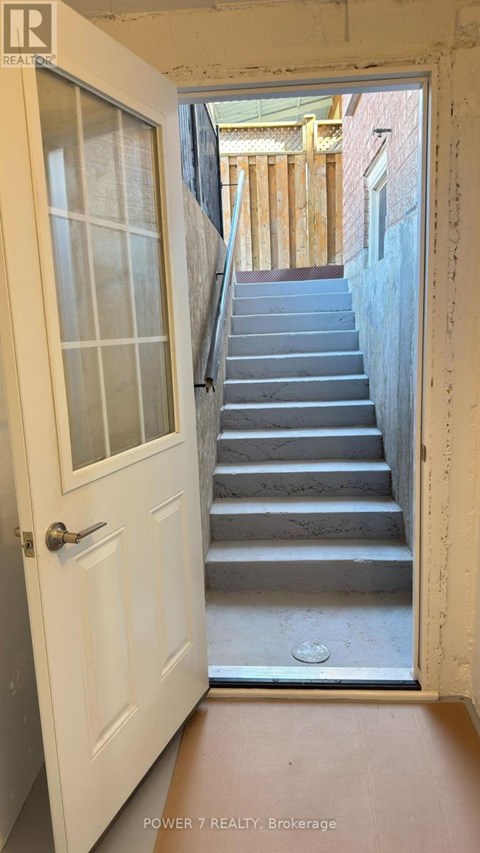 A white door with a glass window is open to a staircase.