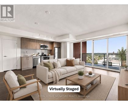 A modern living room with a kitchen in the background and a couch in the foreground.