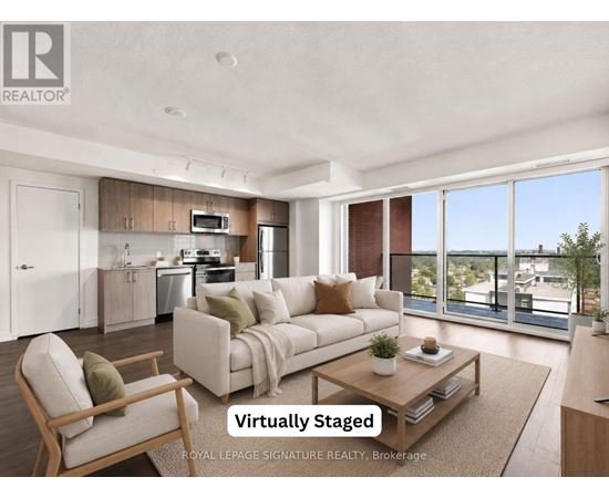A modern living room with a kitchen in the background and a couch in the foreground.